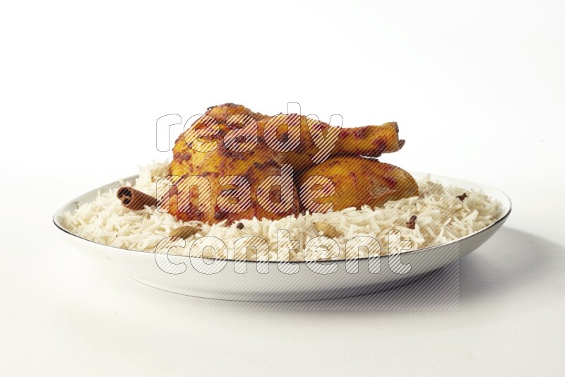 white basmati Rice with kabsa chicken pieces on a white plate with a silver rim direct on white background