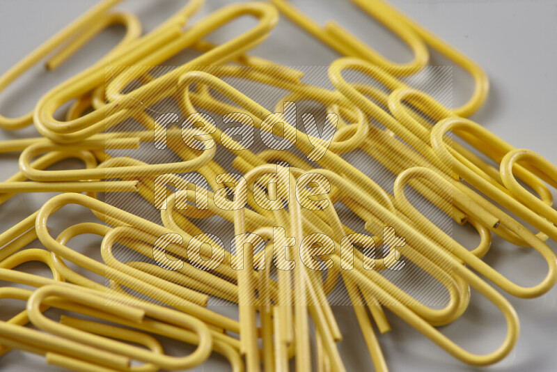 Yellow paper clips isolated on a grey background