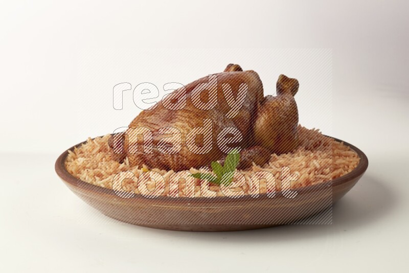 red basmati Rice with whole roasted chicken on a pottery plate direct on white background