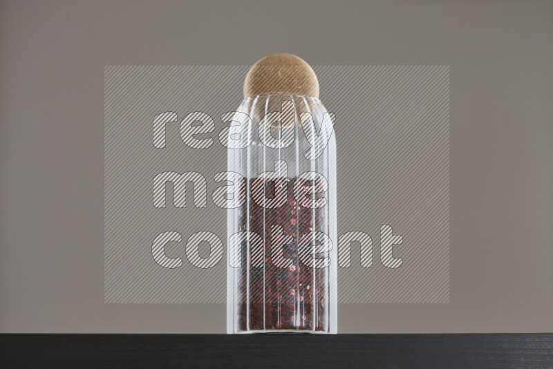 Sequins in a glass jar on black background