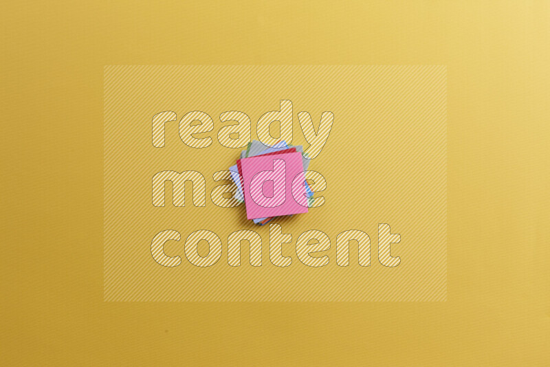 ورق ملاحظات متعدد الألوان مع مستلزمات مدرسية على خلفية صفراء