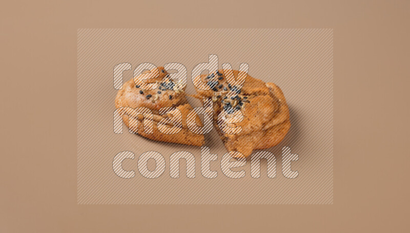 a Hasawi cookie field of date and herbs with another one cut in half on a brown background