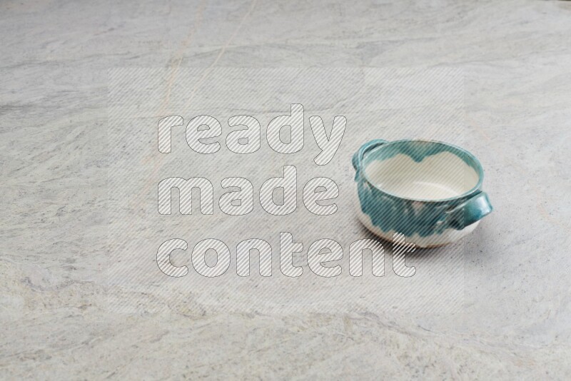 A multicolored pottery bowl on grey marble background