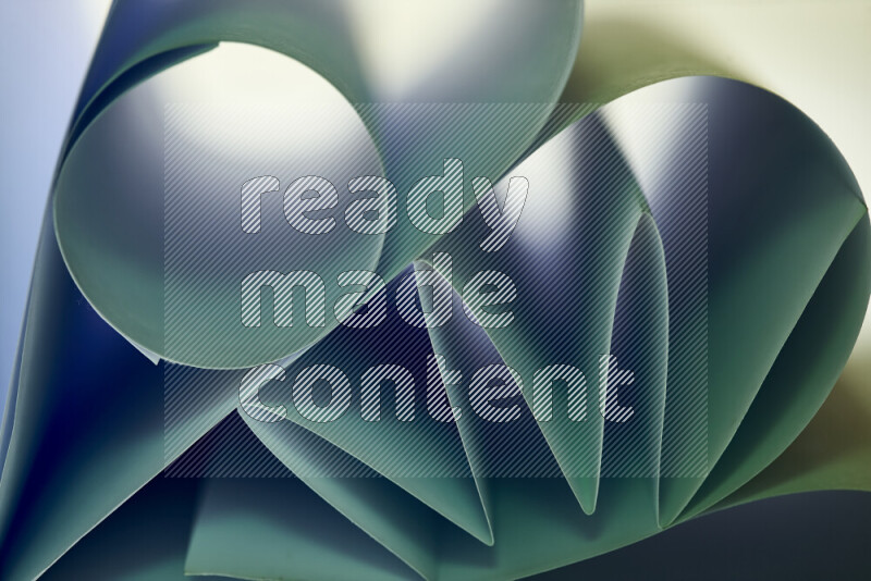 عرض فني لطيات الورق تخلق مزيج من الأشكال الهندسية، مضاءة بإضاءة ناعمة بدرجات اللون الأخضر