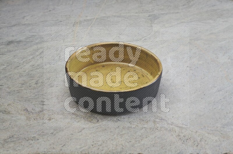 A multicolored pottery oven plate on grey marble background