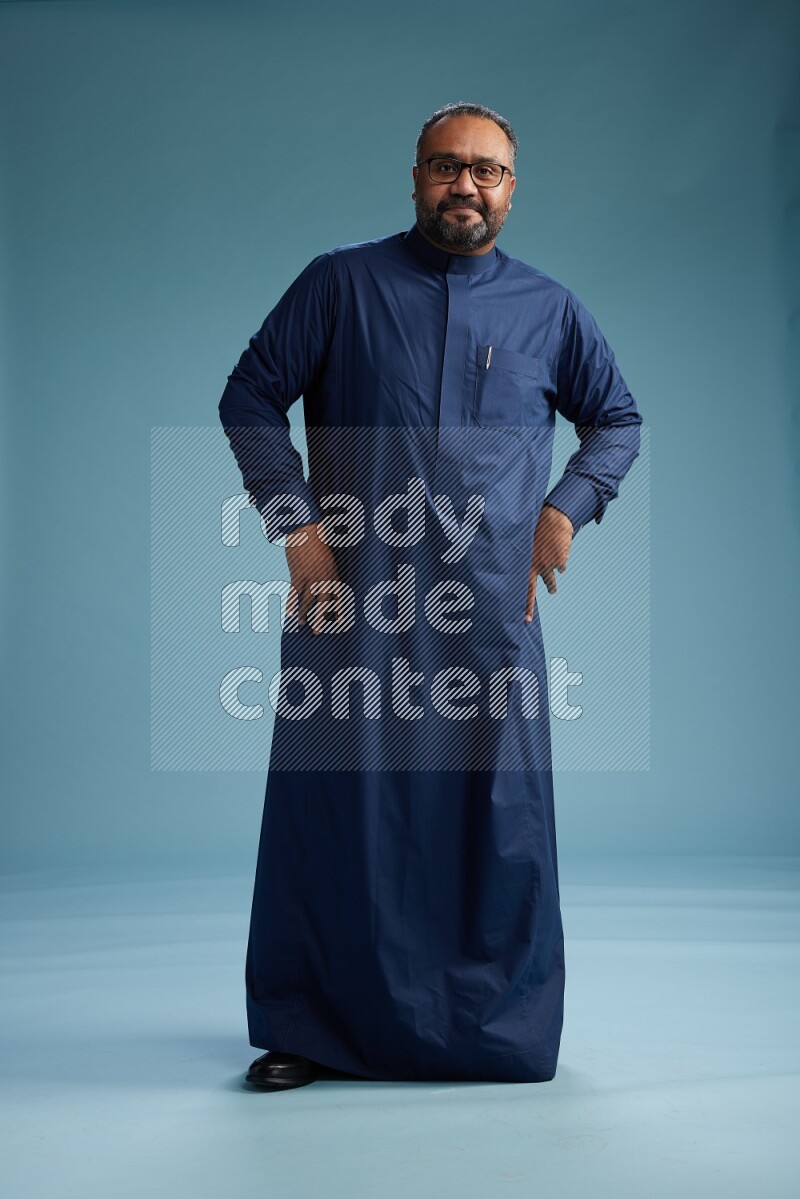 Saudi Man without shimag Standing Interacting with the camera on blue background