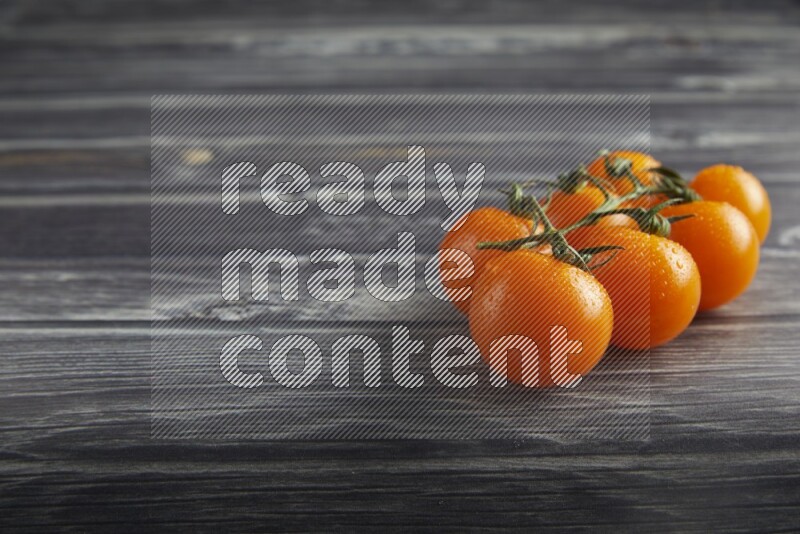 orange cherry tomato vein on a textured grey wooden background 45 degree