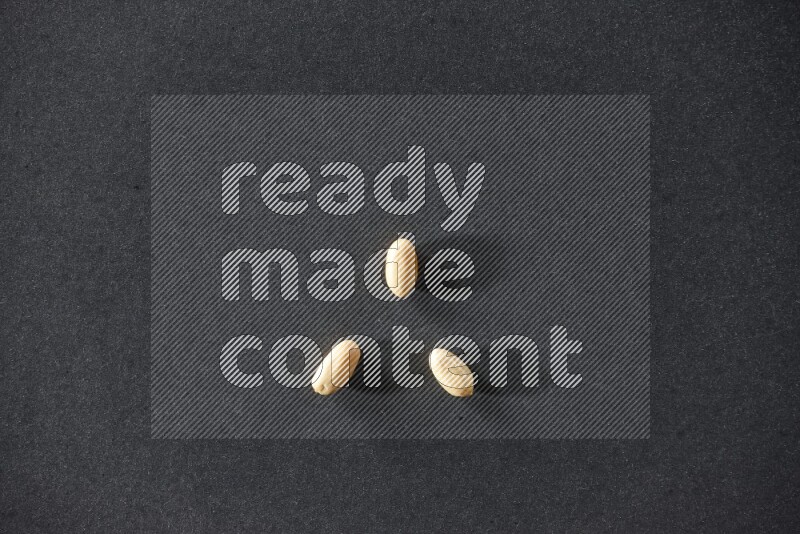 3 peeled peanuts on a black background in different angles