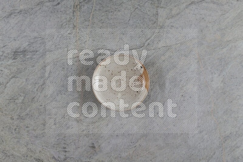 A multicolored pottery plate on grey marble background