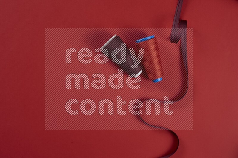 مجموعة من أدوات الخياطة والتفصيل حمراء اللون على خلفية حمراء