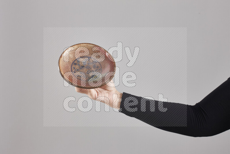 A woman in black abaya holding different pottery essentials in different positions