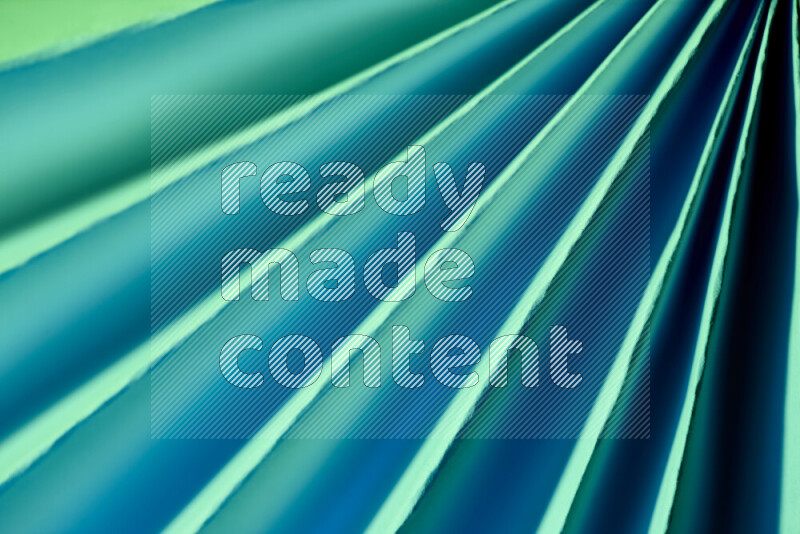 An image presenting an abstract paper pattern of lines in green and blue tones