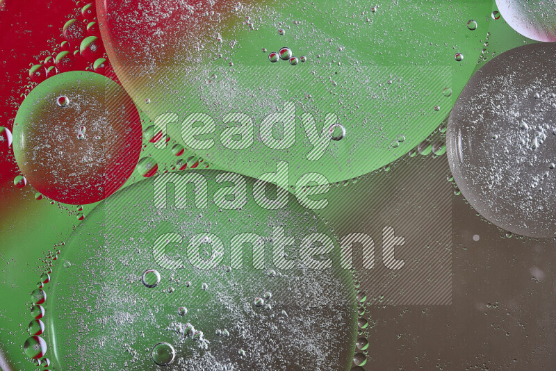 Close-ups of abstract oil bubbles on water surface in shades of brown, green and red