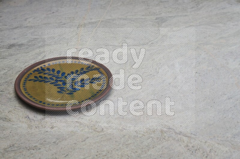 A decorative pottery plate on grey marble background
