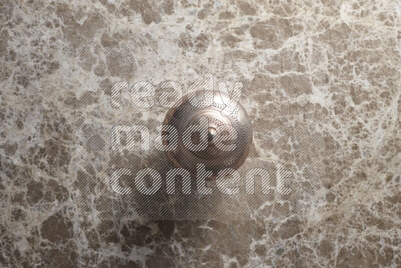 A lantern placed on a beige marble background