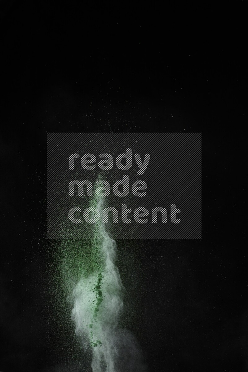 A side view of green powder explosion on black background