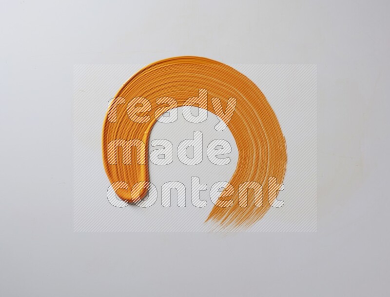 An orange circular painting brush stroke on white background