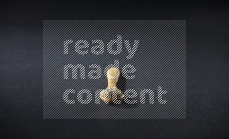 ملعقة خشبية ممتلئة ببودرة الهيل على خلفية سوداء