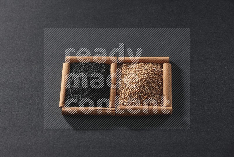 2 squares of cinnamon sticks full of mustard seeds and black seeds on black flooring