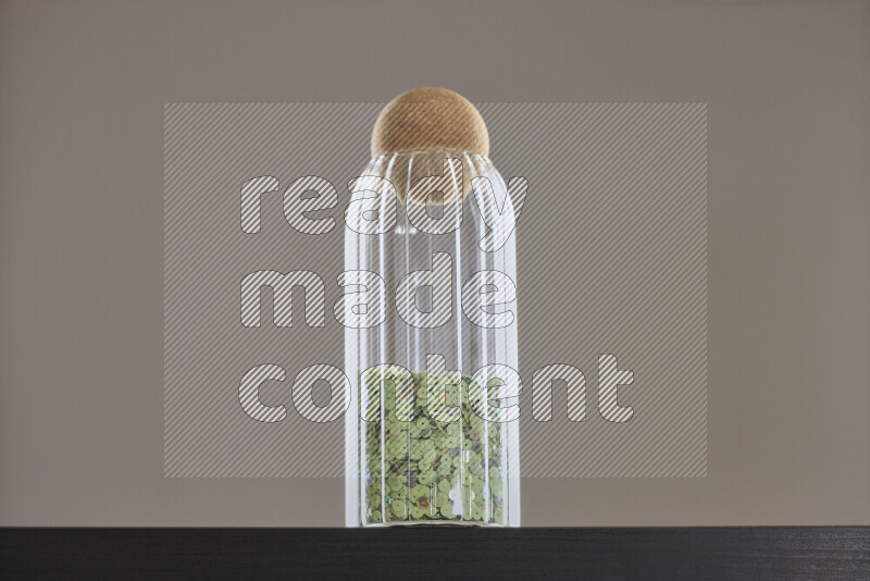 ترتر ملون في وعاء زجاجي علي خلفية سوداء