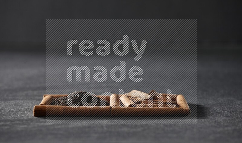 2 squares of cinnamon sticks full of tea and cinnamon on black flooring