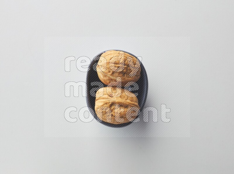 Top-view shot of walnut in a container on white background