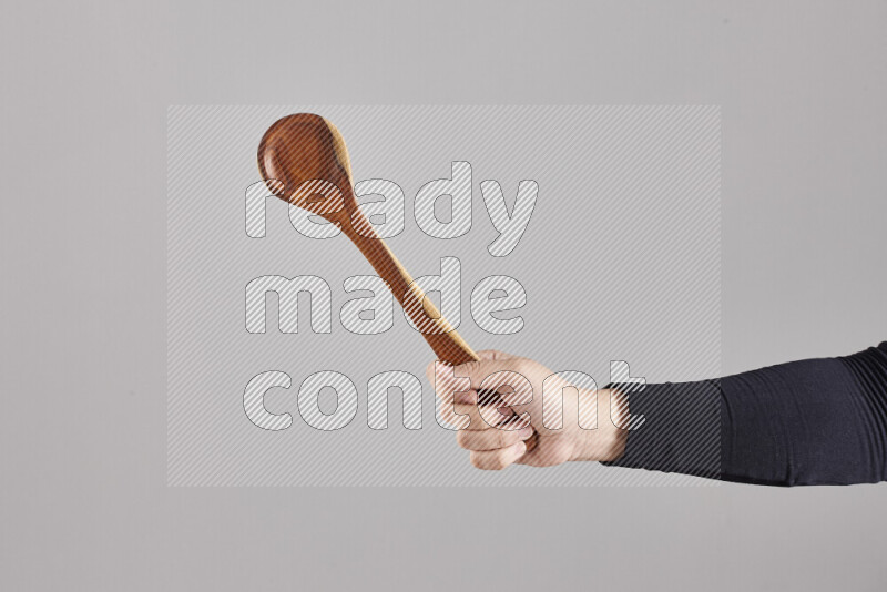 امرأة ترتدي عباءة سوداء تحمل أدوات خشبية مختلفة في أوضاع متعددة