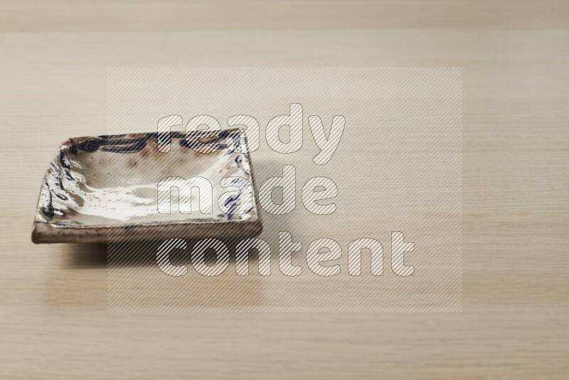 صحن فخاري مزخرف على خلفية خشبية فاتحة