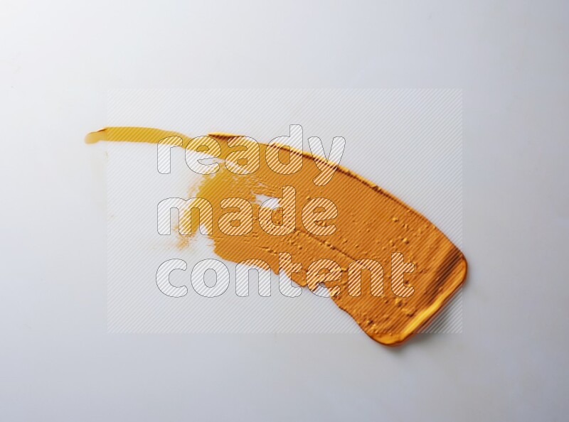 An orange single curved painting knife stroke on white background