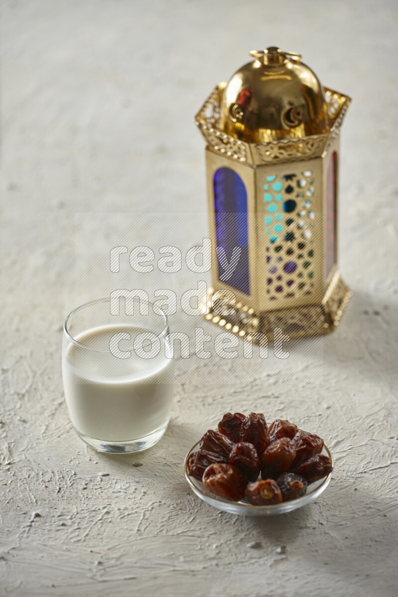A golden lantern with different drinks, dates, nuts, prayer beads and quran on textured white background