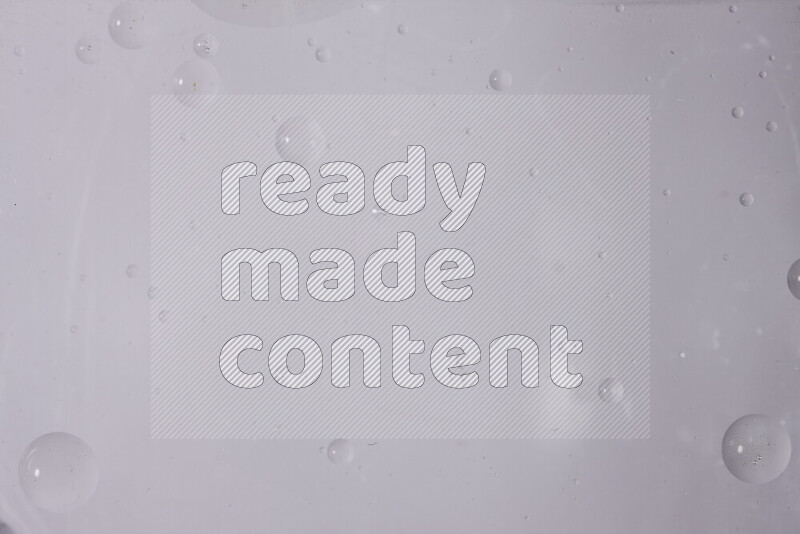 قطرات من الزيت على سطح الماء على خلفية بيضاء