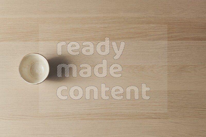 A white pottery bowl on light wooden background