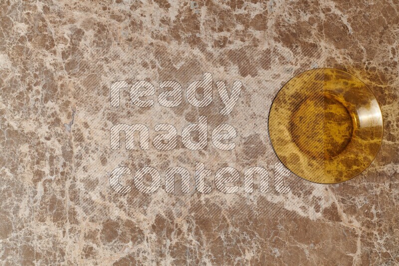 A circular glass plate on beige marble background