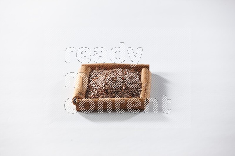 A single square of cinnamon sticks full of flaxseeds on white flooring