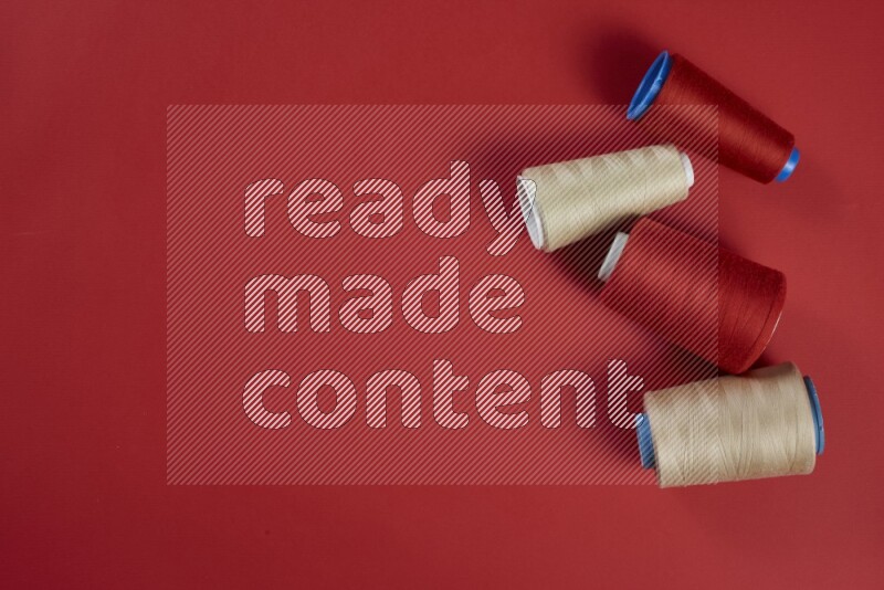 A brown and red collection of sewing and tailoring tools arranged on a red background