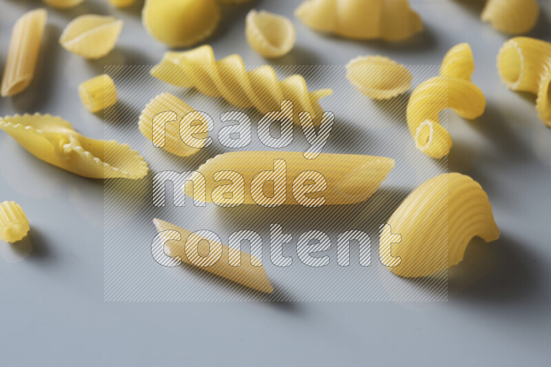 Different pasta types on light blue background