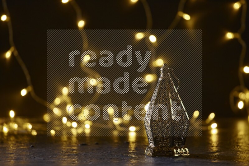 A traditional ramadan lantern surrounded by glowing fairy lights in a dark setup