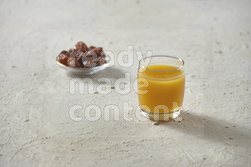 Cold drinks in a glass cup with dates such as water, tamarind, qamar eldin, sobia, milk and hibiscus on textured white background