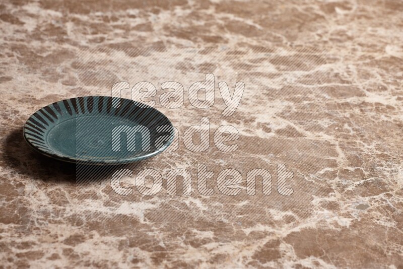 A multicolored pottery plate on beige marble background