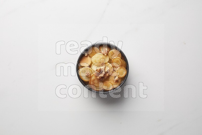 Top-view shot of walnut cereal pancakes in a round bowl on white background