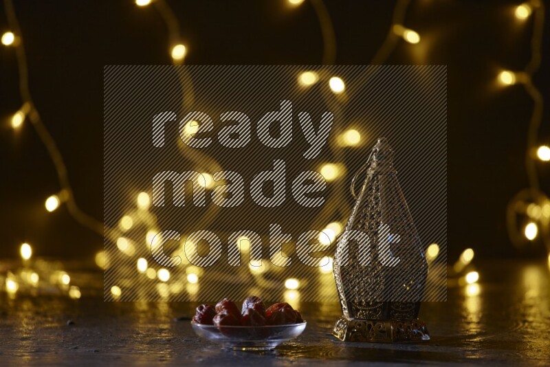A traditional ramadan lantern surrounded by glowing fairy lights in a dark setup