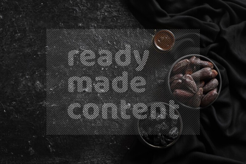 Dried fruits in pottery bowls with coffee in a dark setup