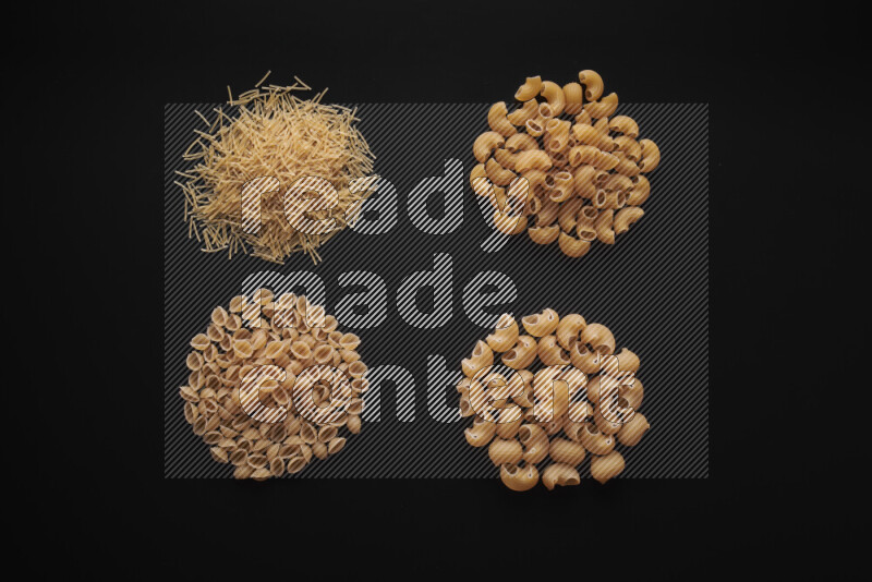 Different pasta types in bunches on black background