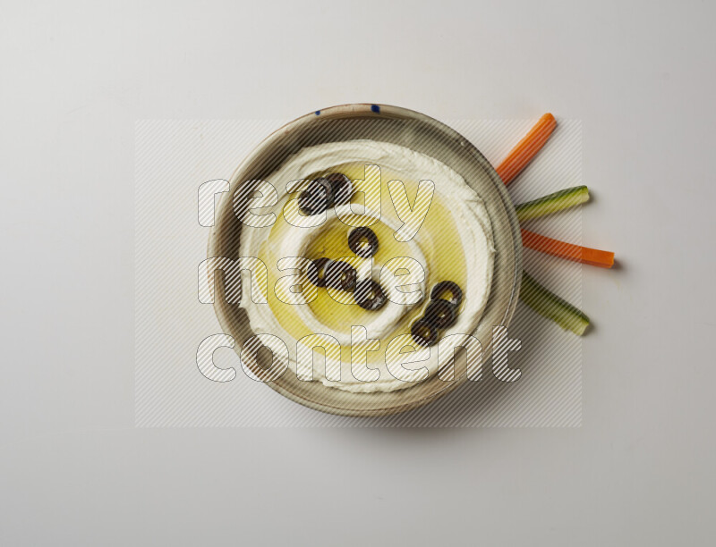 Lebnah garnished with sliced olives in a grey pottery plate on a white background