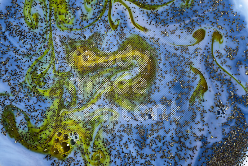 A close-up of sparkling gold glitter scattered on swirling blue and green background