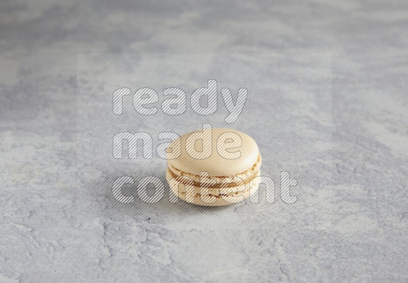 45º Shot of white marbleCaramel fleur de sel macaron on white  marble background