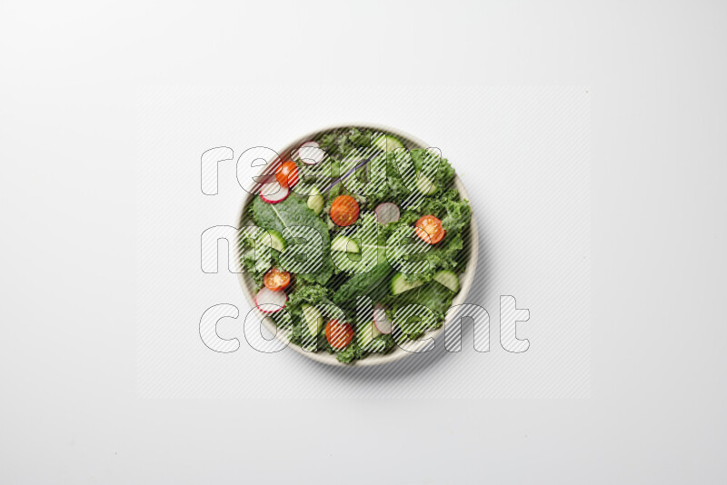 A bowl of fresh vegetables salad with kale leaves, cherry tomatoes, sliced radishes and sliced cucumber on a white background