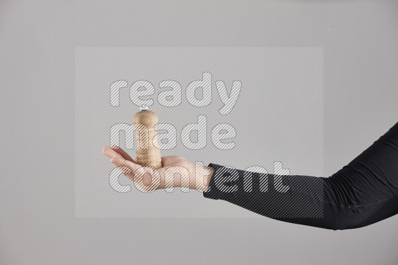 امرأة ترتدي عباءة سوداء تحمل أدوات خشبية مختلفة في أوضاع متعددة