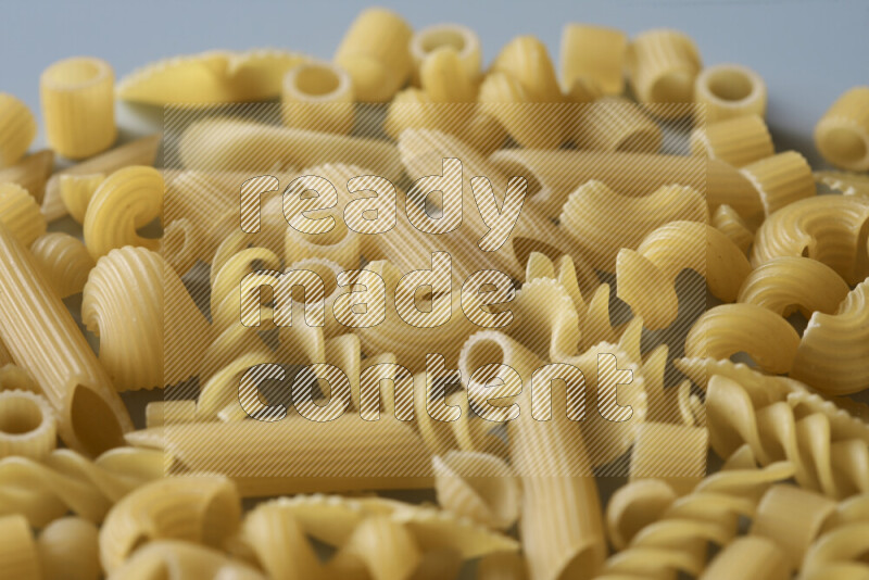 Different pasta types on light blue background