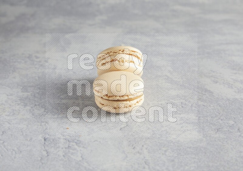 45º Shot of two white marbleCaramel fleur de sel macarons  on white  marble background